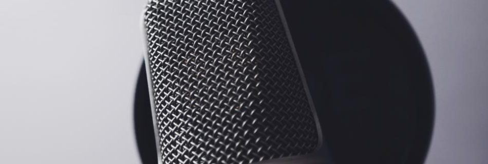Close-up of a studio condenser microphone in front of a pop filter